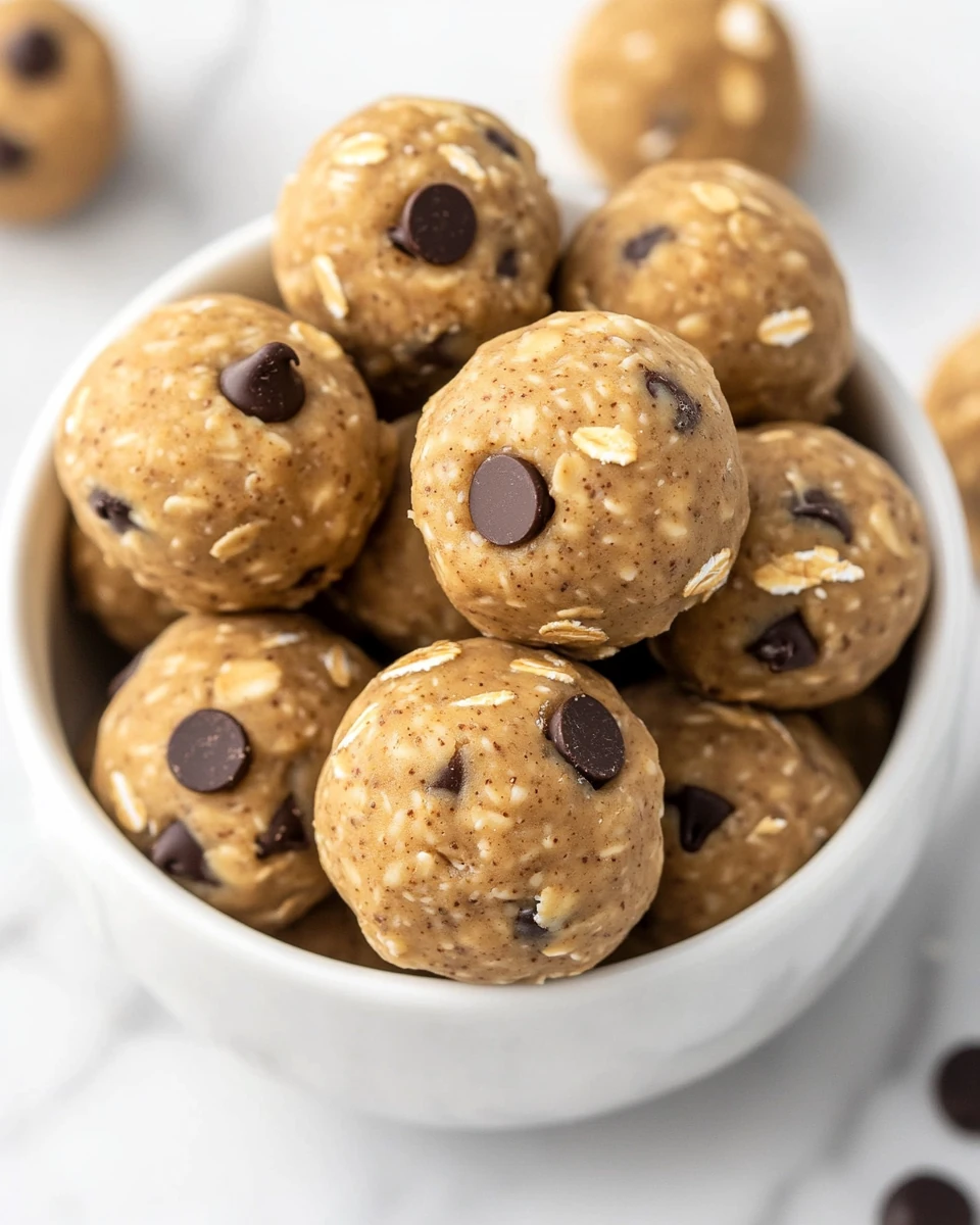 Protein Balls in a white bowl with peanut butter, oats, and mini chocolate chips