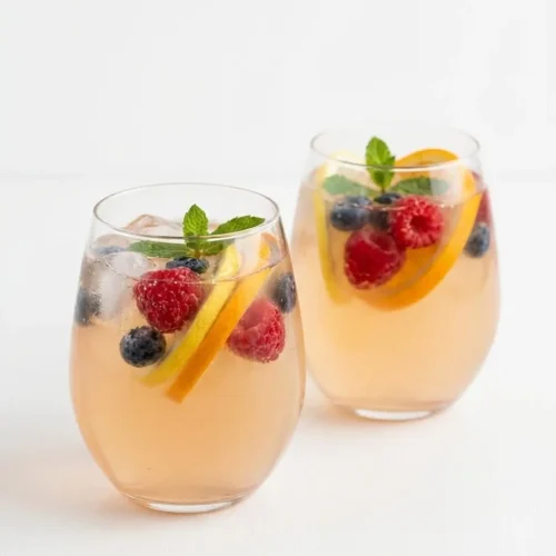 Two glow spritzers with berries and citrus showing benefits of kombucha for females in a light drink
