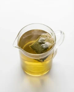 Jug of hot green tea as the first step in a kombucha recipe for weight loss