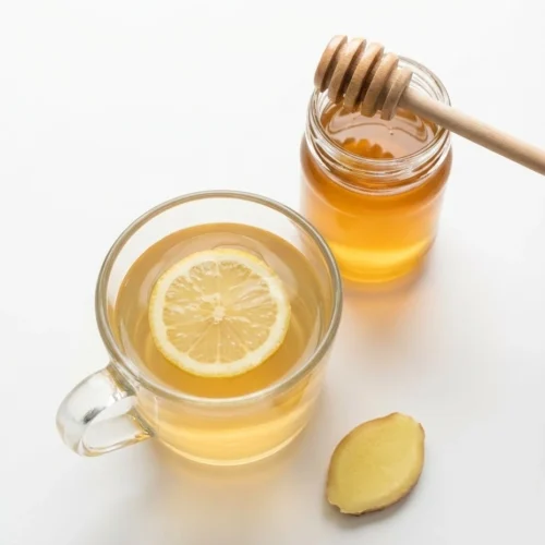 Top view of canaan honey eye comfort drink with lemon and honey jar on white.