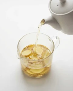 Kombucha Gut Health And Probiotics For Happier Digestion 3 Ginger and chamomile tea being combined as the base for a kombucha gut health tonic