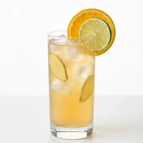 Tall glass of citrus ginger kombucha with ice and orange and lime slices on white background
