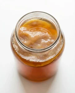 Jar of kombucha with SCOBY fermenting as part of a kombucha recipe for weight loss