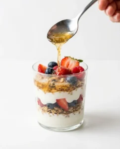 Kombucha drizzled over a kefir parfait as the final step in the kefir kombucha recipe