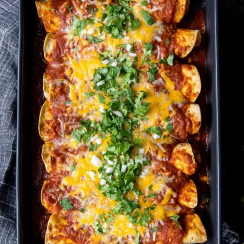 Turkey enchiladas topped with cheese and cilantro.