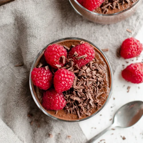 Delicious chocolate chia pudding with raspberries and chocolate shavings.