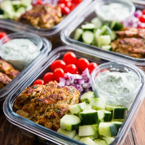 Greek Chicken: A Flavorful and Healthy Delight 1 Healthy Greek chicken meal prep bowls with salad and sauce.