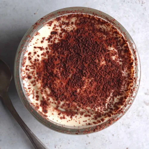 High protein tiramisu dessert served in a glass cup.