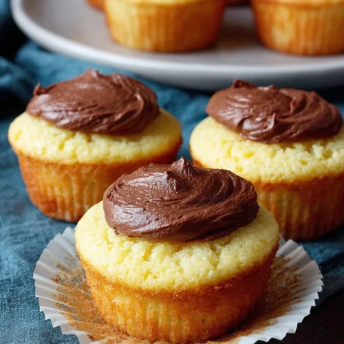 Delicious yellow cupcakes topped with chocolate frosting.