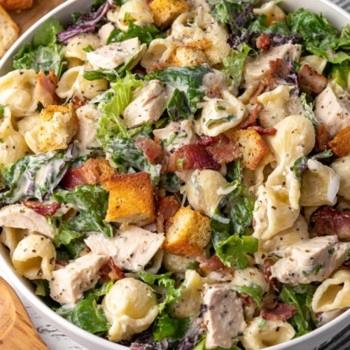 Creamy chicken caesar pasta salad with bacon and croutons.
