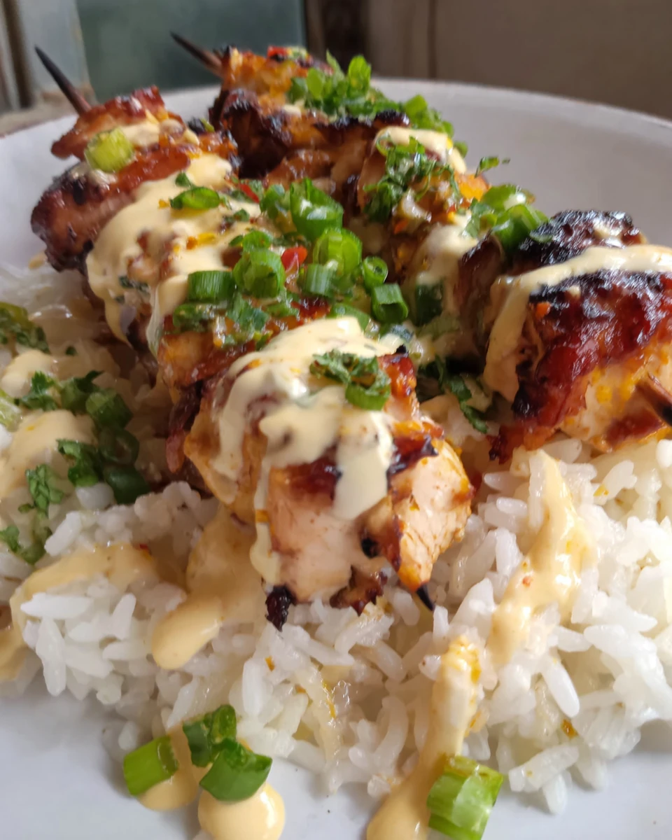 Juicy chili lime chicken skewers with creamy sauce on white rice