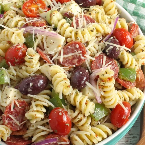 Classic pasta salad with tri-color rotini, pepperoni, tomatoes, and cheese in a bowl