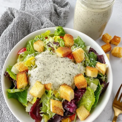 Creamy pesto salad dressing over a fresh salad with croutons.