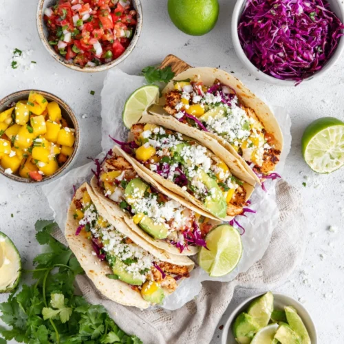 Grilled chicken tacos with mango salsa, cabbage slaw, avocado, and cotija cheese