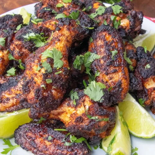 Grilled Dry Rub Chicken Wings: Irresistibly Crispy and Flavorful 1 Grilled dry rub chicken wings with lime and cilantro on a white plate