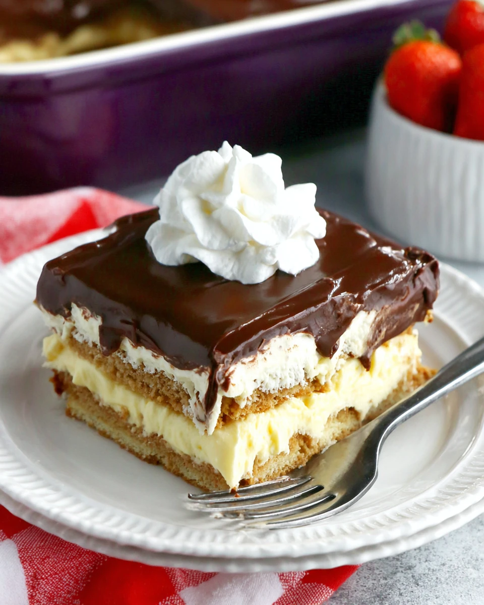 No-bake chocolate eclair cake slice with chocolate frosting and whipped cream