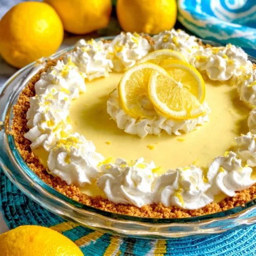 No-bake lemon icebox pie with graham cracker crust, whipped cream, lemon slices, and zest on a colorful plate
