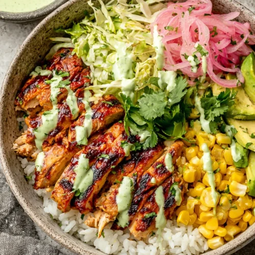 Oven Baked BBQ Chicken Rice Bowls: A Flavorful Delight 1 Oven baked BBQ chicken rice bowl with corn, avocado, and pickled onions