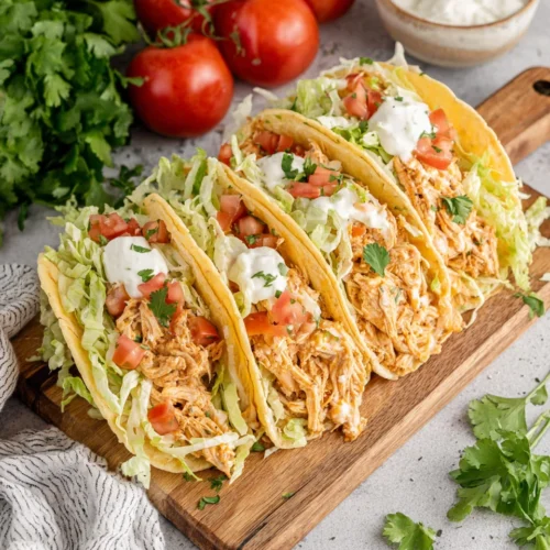 Queso chicken tacos ready to serve with fresh toppings.