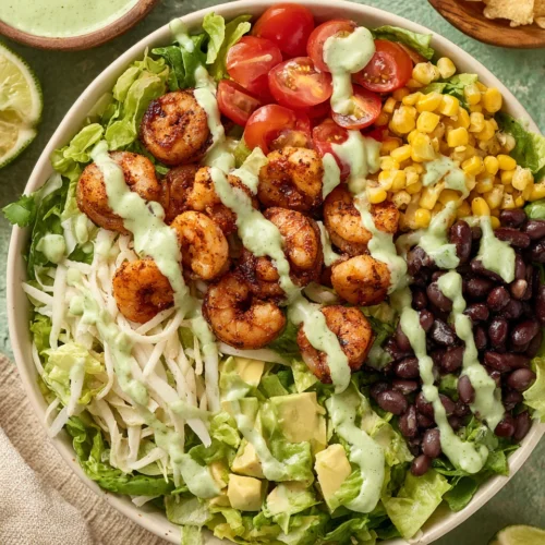 Shrimp taco salad with fresh veggies and creamy dressing.
