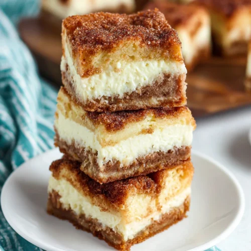 Sopapilla cheesecake bars with crispy layers and cinnamon topping.