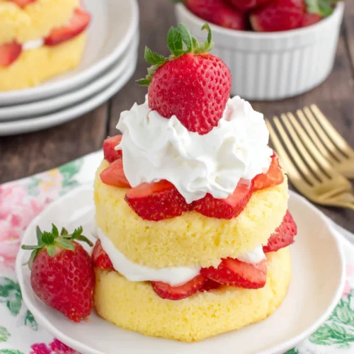 Strawberry shortcake with fresh strawberries and whipped cream on a white plate