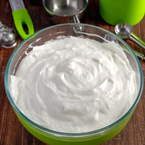 White royal icing in a glass bowl for airbrushed patriotic bunting cookies