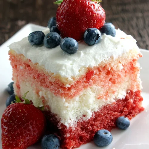 American flag strawberry poke cake slice with strawberries and blueberries