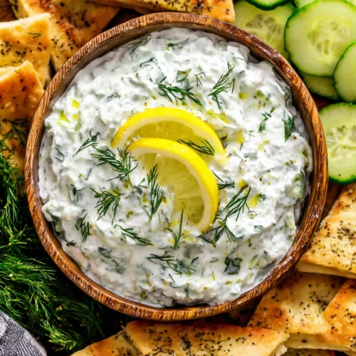 Authentic Greek tzatziki with lemon, dill, and cucumber in a wooden bowl