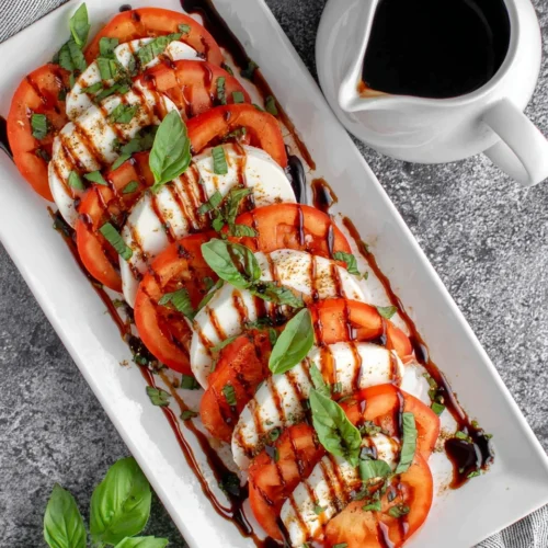 Caprese salad drizzled with balsamic glaze and fresh basil