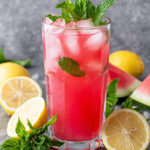 Best watermelon lemonade in a glass with ice, mint, and lemon slices