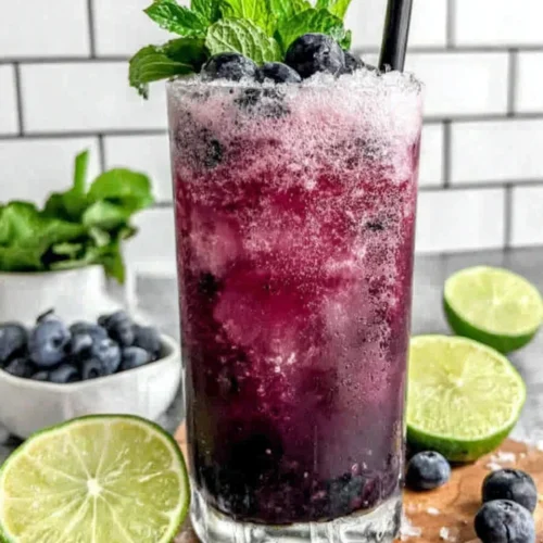 Refreshing blueberry agua fresca in a glass with mint and lime garnish