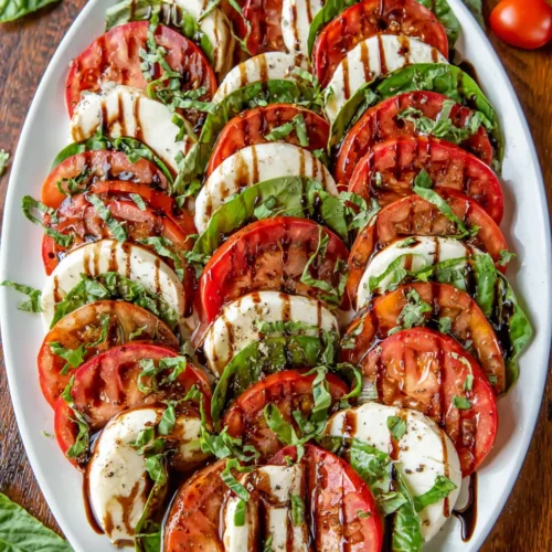 Caprese salad with balsamic glaze on a white platter