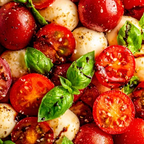 Cherry tomato caprese salad with mozzarella and basil, garnished with balsamic glaze