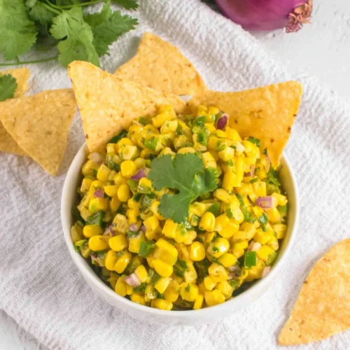 Chipotle Corn Salsa Copycat Recipe: A Flavorful Delight 1 Chipotle corn salsa with tortilla chips and fresh cilantro on a white tablecloth