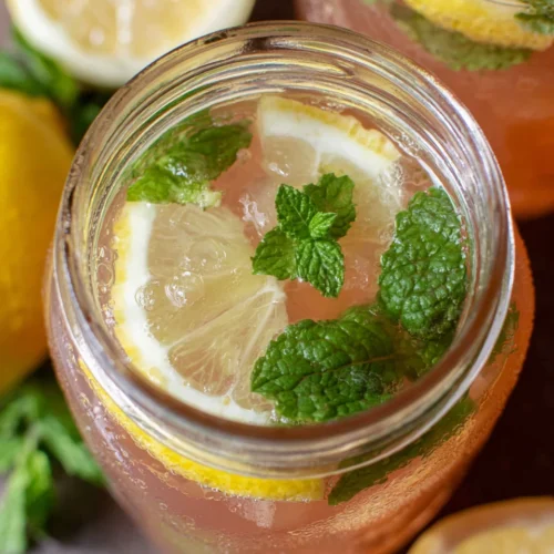 Copycat Chick-Fil-A watermelon mint lemonade in a glass jar with lemon slices and mint