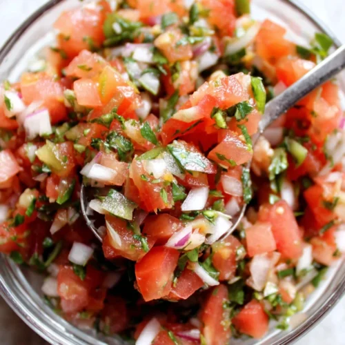 Copycat Chipotle pico de gallo in a glass bowl with fresh tomatoes, onions, cilantro, and jalapenos