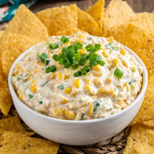 Creamy corn dip with tortilla chips, perfect for parties