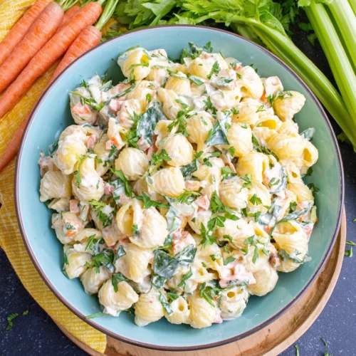 Creamy Macaroni Pasta Salad: A Refreshing Delight 1 Creamy macaroni pasta salad in a bowl with fresh vegetables and herbs
