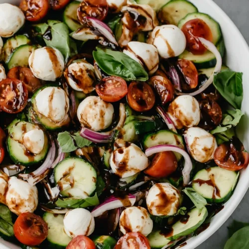 Cucumber caprese salad with balsamic glaze, fresh mozzarella, tomatoes, and basil