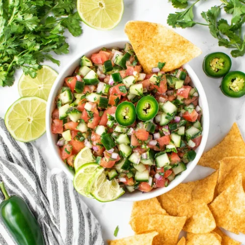 Fresh cucumber pico de gallo with lime and jalapeño, served in a white bowl with tortilla chips.