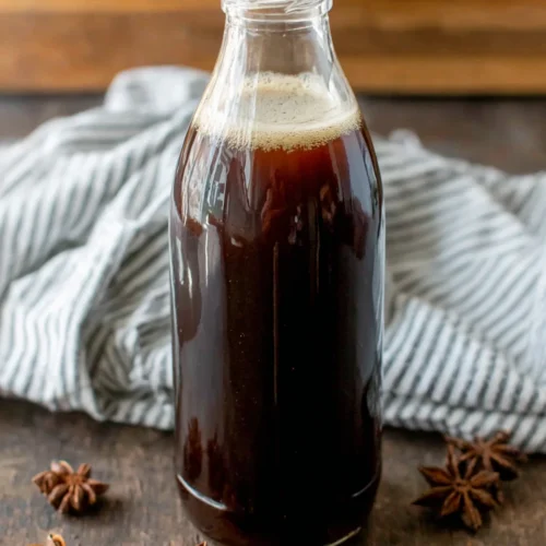 Easy chai concentrate in a glass bottle with star anise on wood background