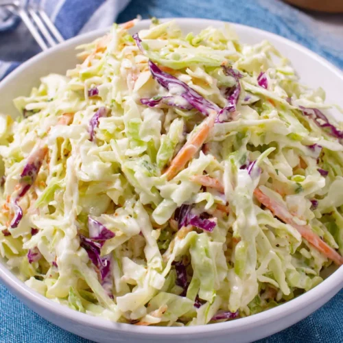 Creamy easy coleslaw with shredded cabbage and carrots in a white bowl