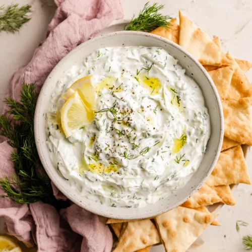 Easy dairy-free tzatziki in a bowl with lemon and dill, served with pita chips