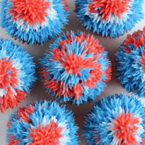 Easy fireworks cupcakes with red, white, and blue frosting in a burst design