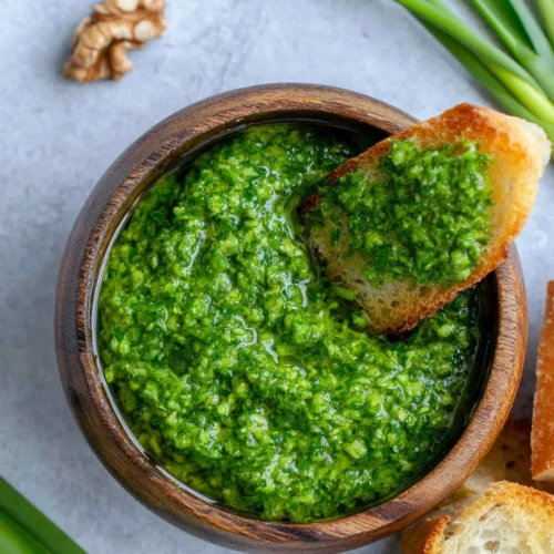 Easy garlic scape pesto in a wooden bowl with bread, fresh and vibrant