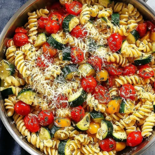 Fresh garden tomato zucchini pasta with fusilli, zucchini, tomatoes, and Parmesan in a skillet