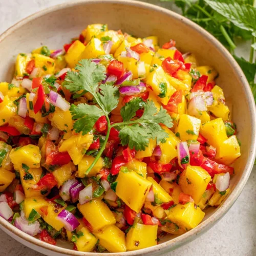 Fresh mango salsa with diced mango, bell pepper, cilantro, and jalapeño in a bowl