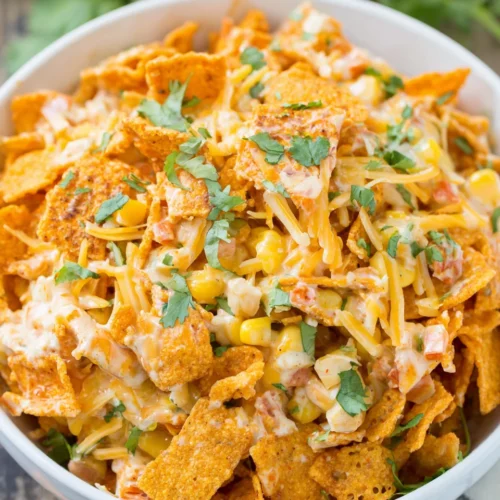 Fritos corn salad with corn, cheese, and crushed Fritos in a white bowl