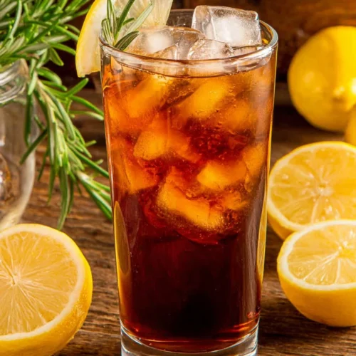 Homemade Lemon Sweet Tea: A Refreshing Delight 1 Homemade lemon sweet tea in a glass with ice, lemon slice, and rosemary garnish